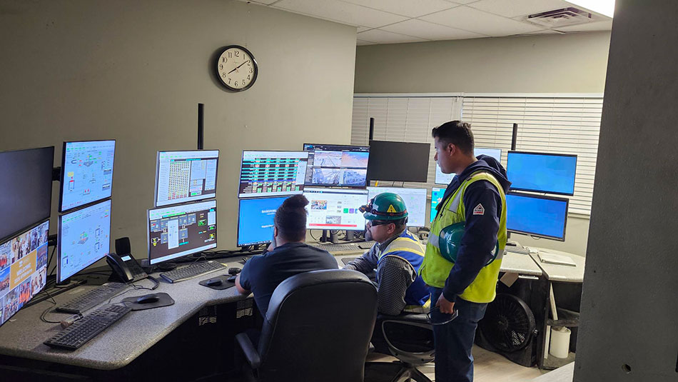 Charlie Garcia (center) and fellow intern Kevin Carrion (right) learn how automated systems are used in mining from Travis Jones, Mill Operator II.