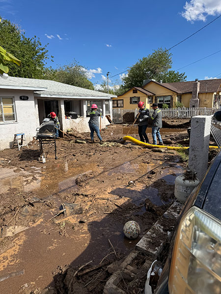 Workers from the Miami operation were quick to volunteer when their help was needed to clear mud from flooded houses.
